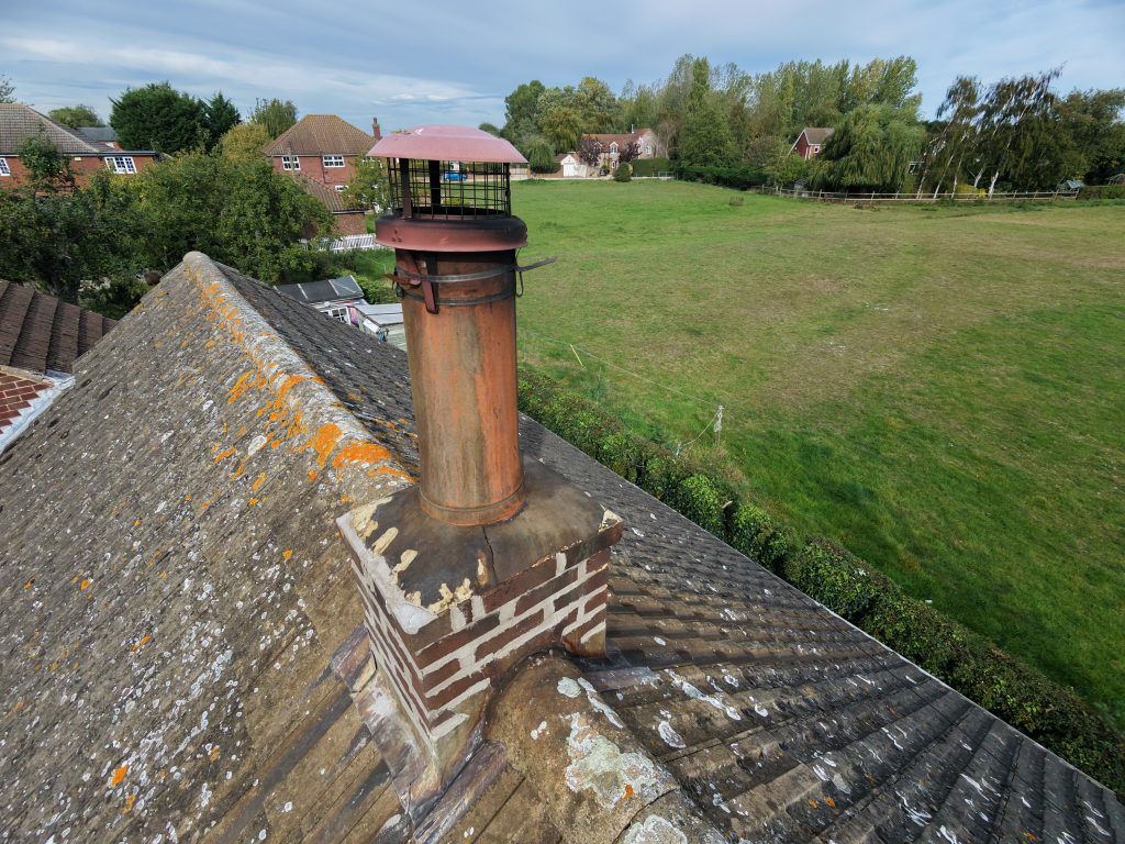 Aerial view of a roof and chimney showing mortar detail that warrants closer inspection
