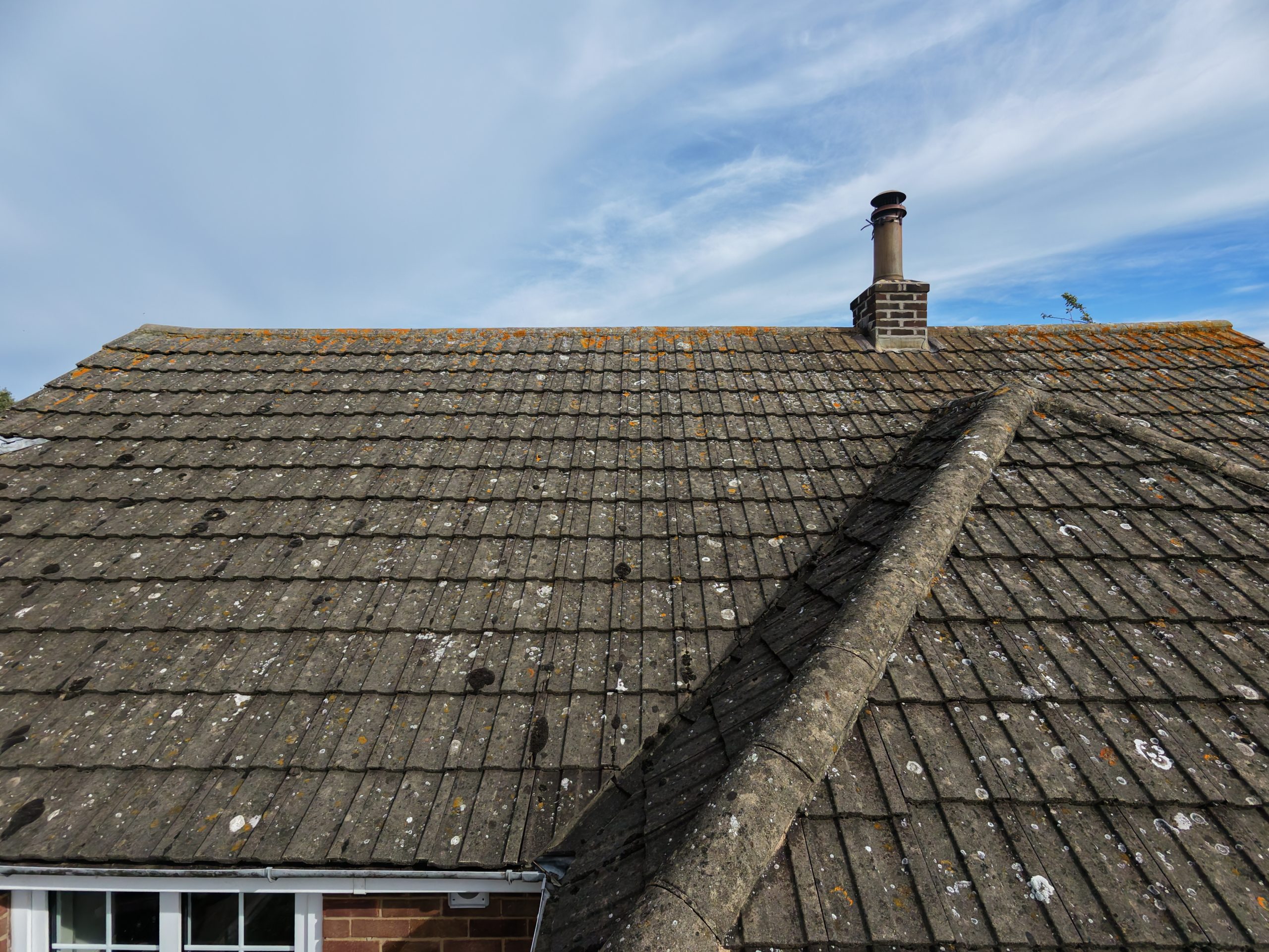 Oblique aerial photograph of a tiled annex roof, ridge tiles and chimney.