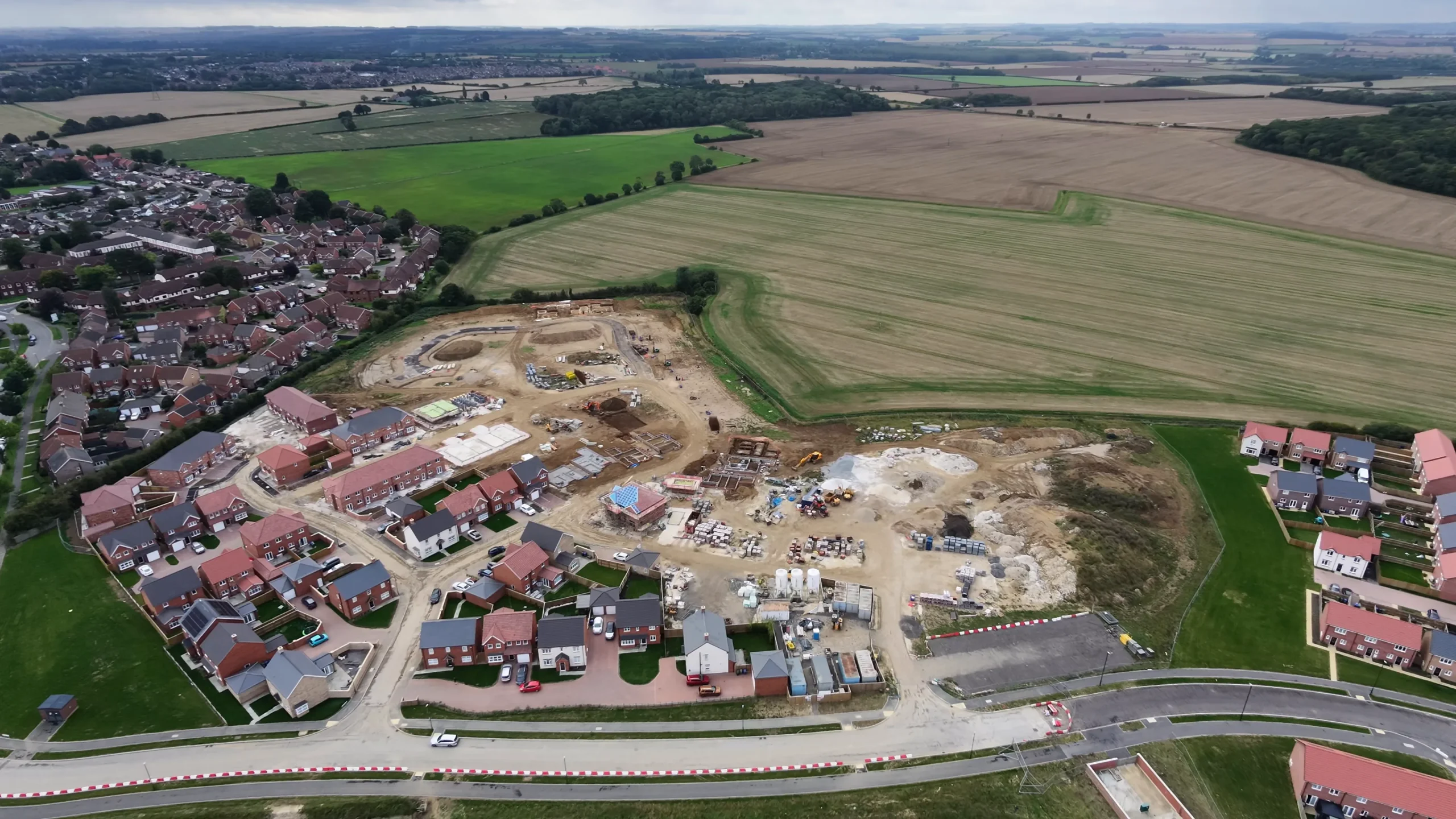 Aerial view of a Grimsby housing development showing completed homes, active building plots and the surrounding site.